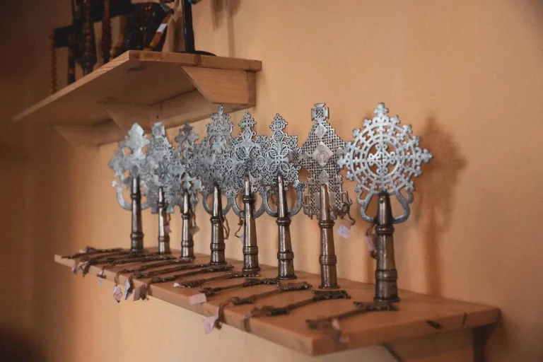 Several Ethiopian crosses, crafted from metal and with intricate designs, are on display. These are religious artifacts representing Ethiopian heritage and culture.