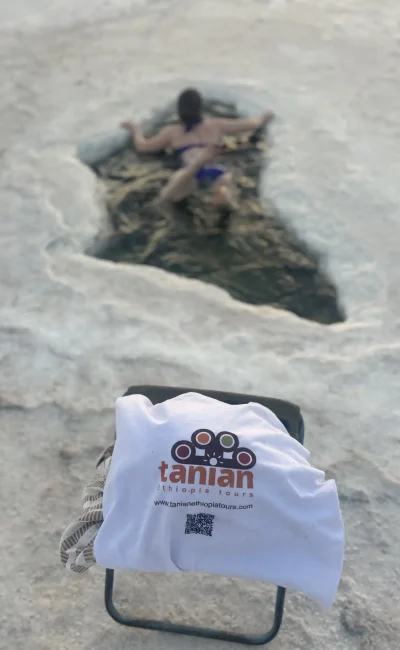 A Tanian Ethiopia Tours client experiences the otherworldly beauty of Dallol, Ethiopia, with a swim in its unique mineral pool.